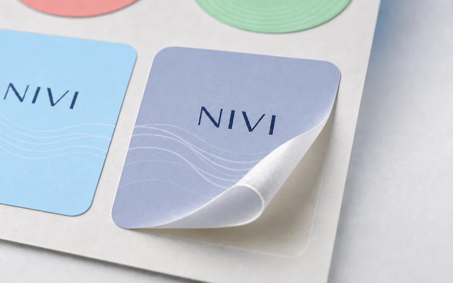 Macro view of a sheet label lifting from its backing liner